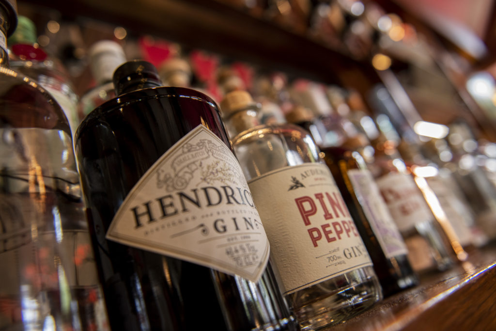 Close-up of gin bottles lined up behind the bar at The Cambria