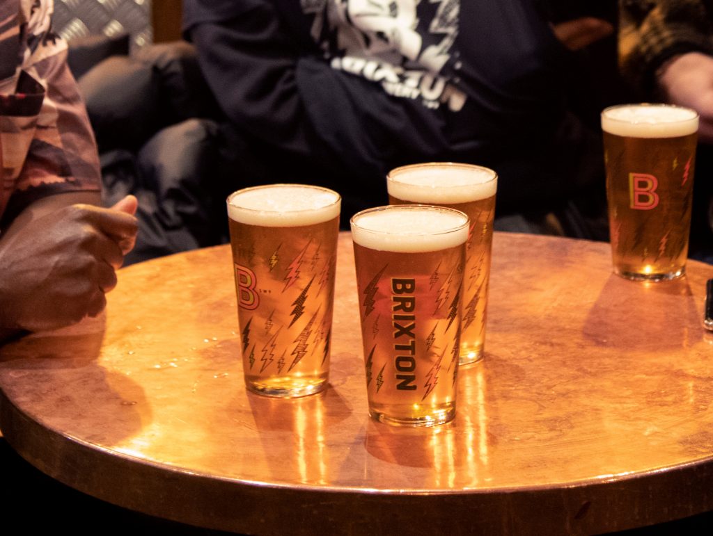Four pints of beer on a wooden table at The Cambria