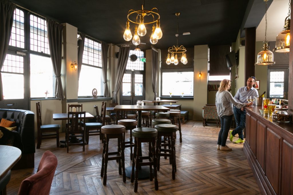 Spacious interior of The Cambria with wooden tables, stools and large windows