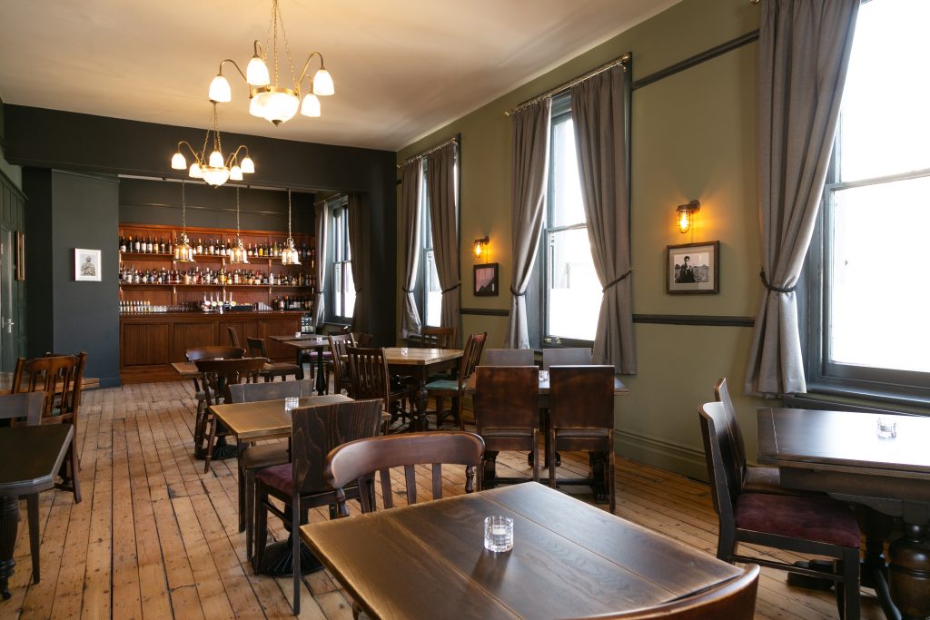 Private room at The Cambria with wooden tables, large windows and its own bar