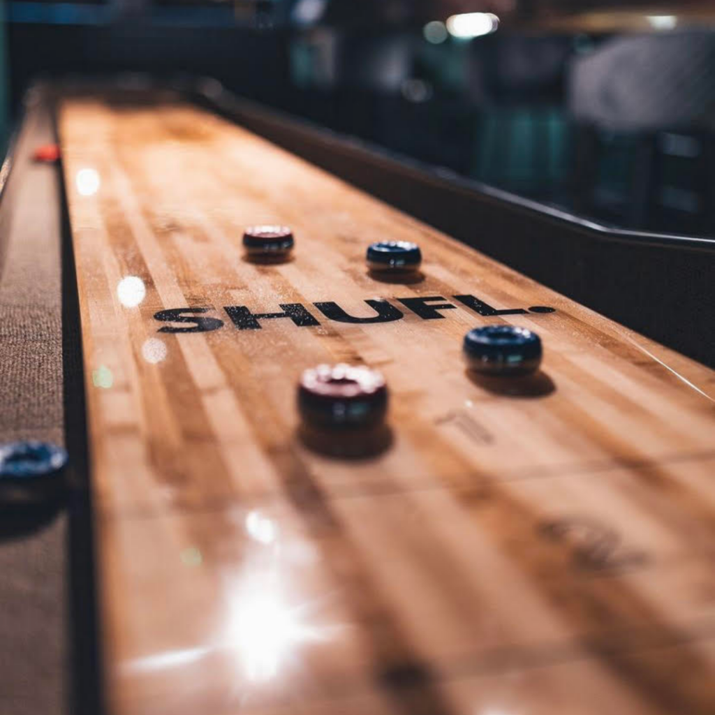 Red and blue pucks on a wooden shuffleboard table