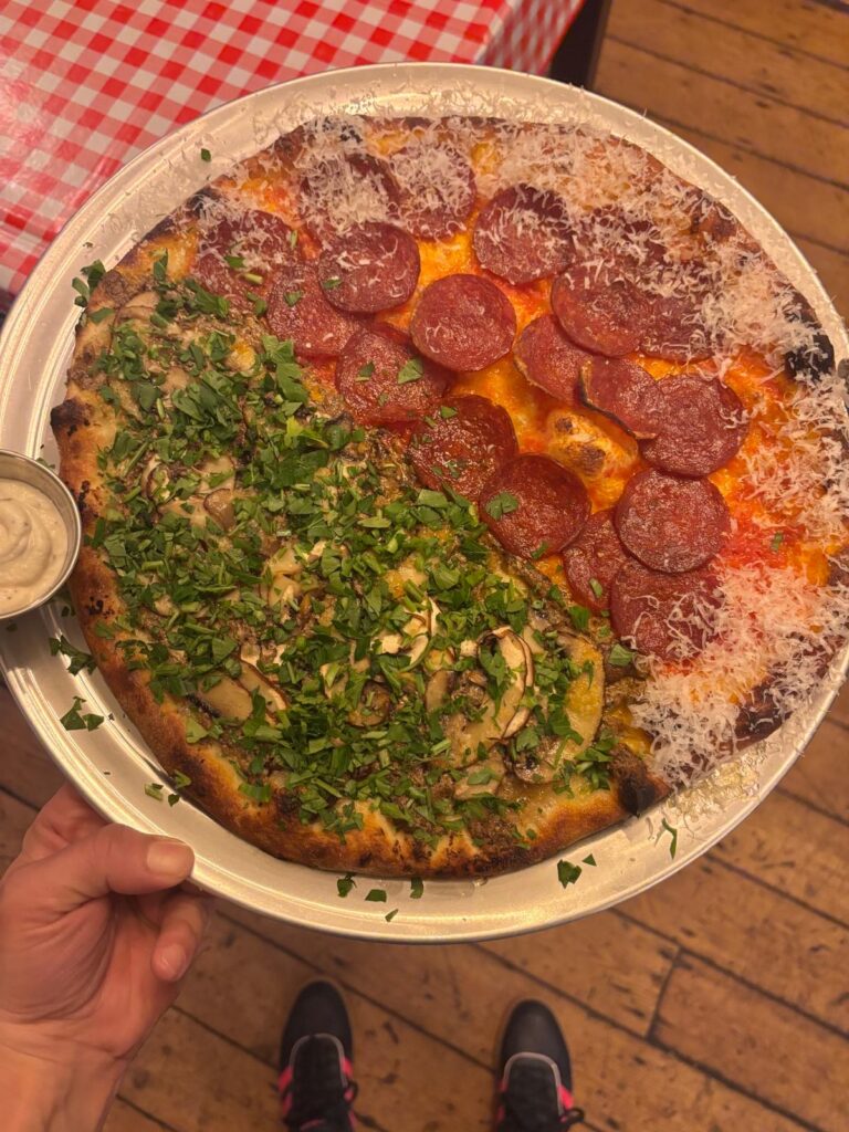 Half-and-half pizza with pepperoni, mushrooms and fresh chopped herbs