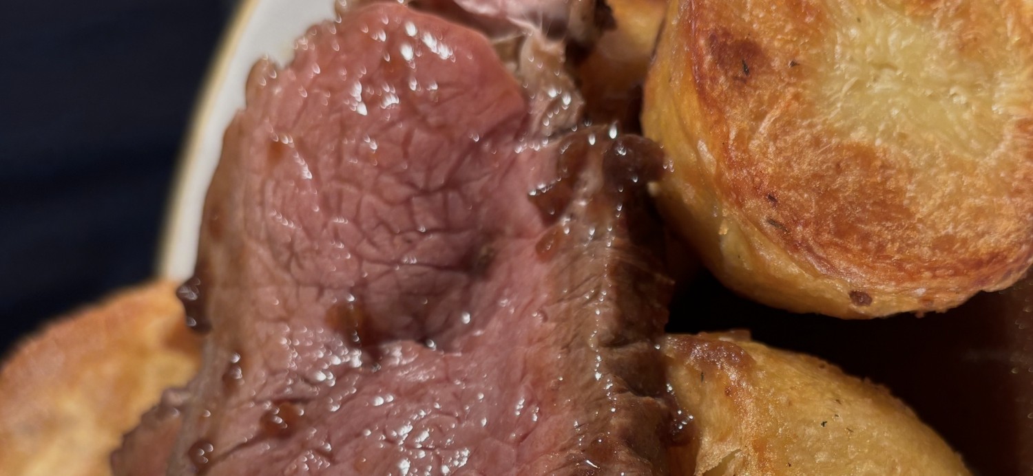 Sliced roast beef with Yorkshire pudding and golden roast potatoes
