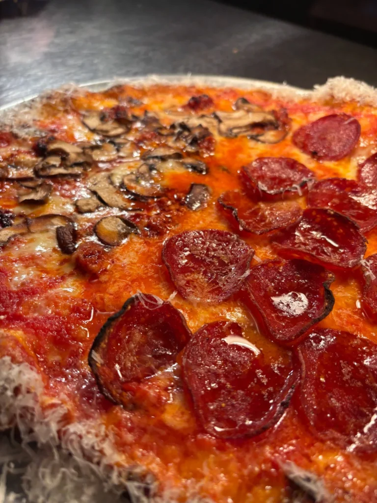 Close-up of pizza topped with pepperoni and mushrooms